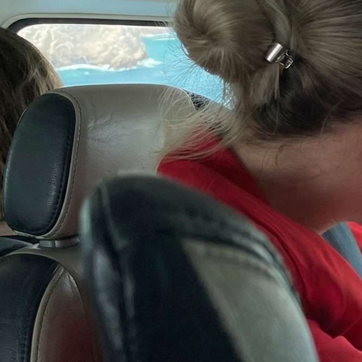 Passengers seated inside an aircraft cabin with the coastline ahead