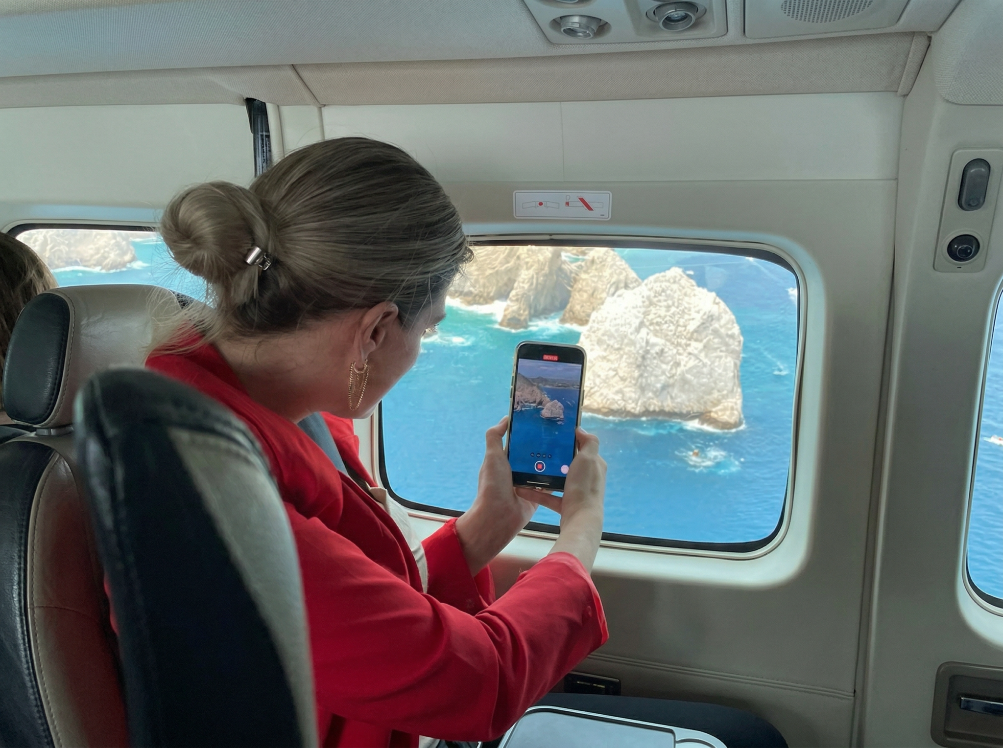 Passenger photographing El Arco in Cabo San Lucas from inside a private charter flight