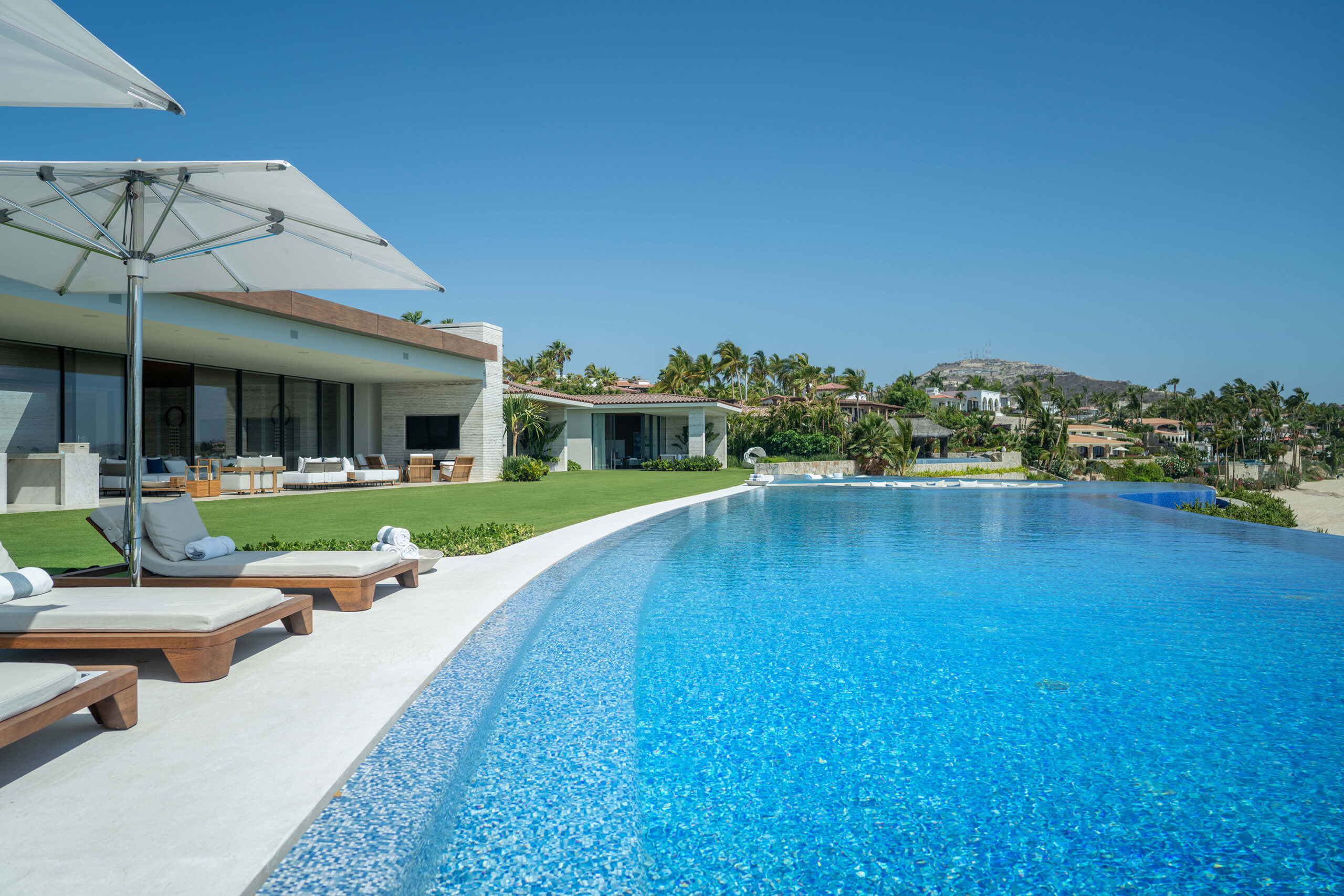 Casa Elije poolside patio with lounge chairs and ocean views in Palmilla Los Cabos