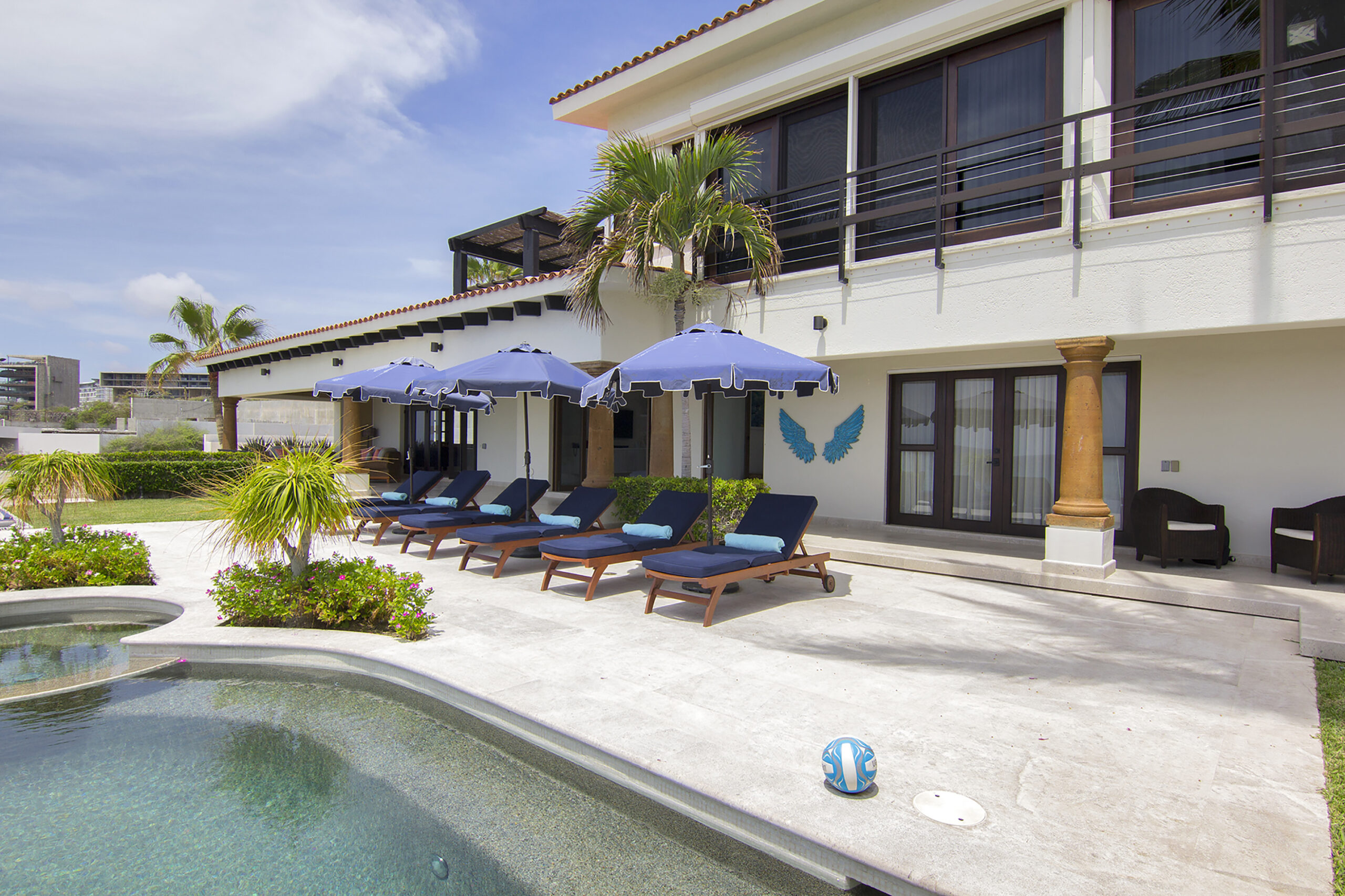 Villa Delfines poolside view with lounge chairs in Cabo Real, Beachfront Los Cabos