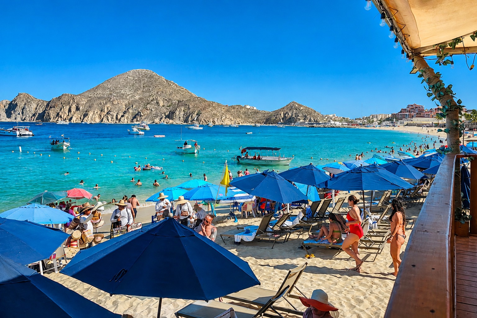 Médano Beach with beach umbrellas and the Cabo San Lucas bay
