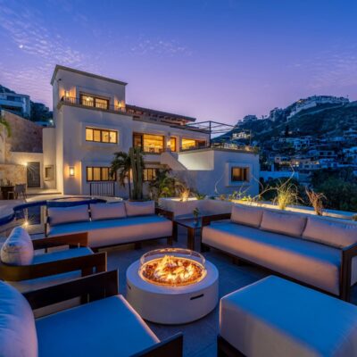 Sunset panorama across the pool, firepit lounge, and Pedregal hills at Casa La Piñata in Pedregal